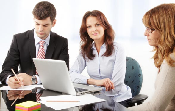 People conversing around a computer