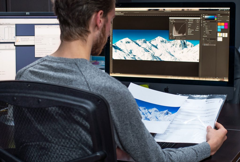 man inspecting artwork in the prepress deparment