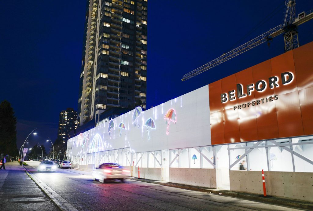 Brightly-lit construction hoarding at night