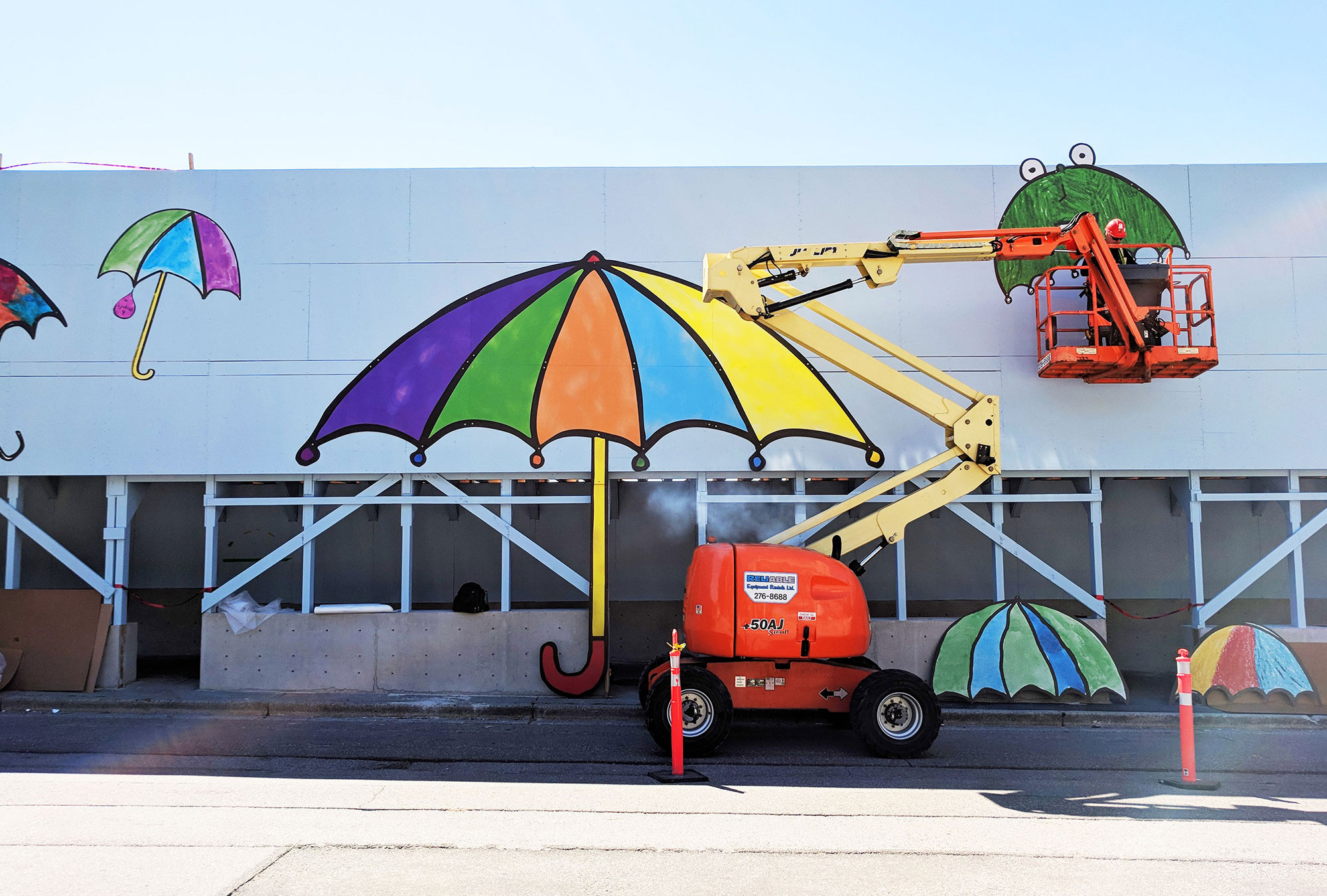 Man installing outdoor signage on a boom lift